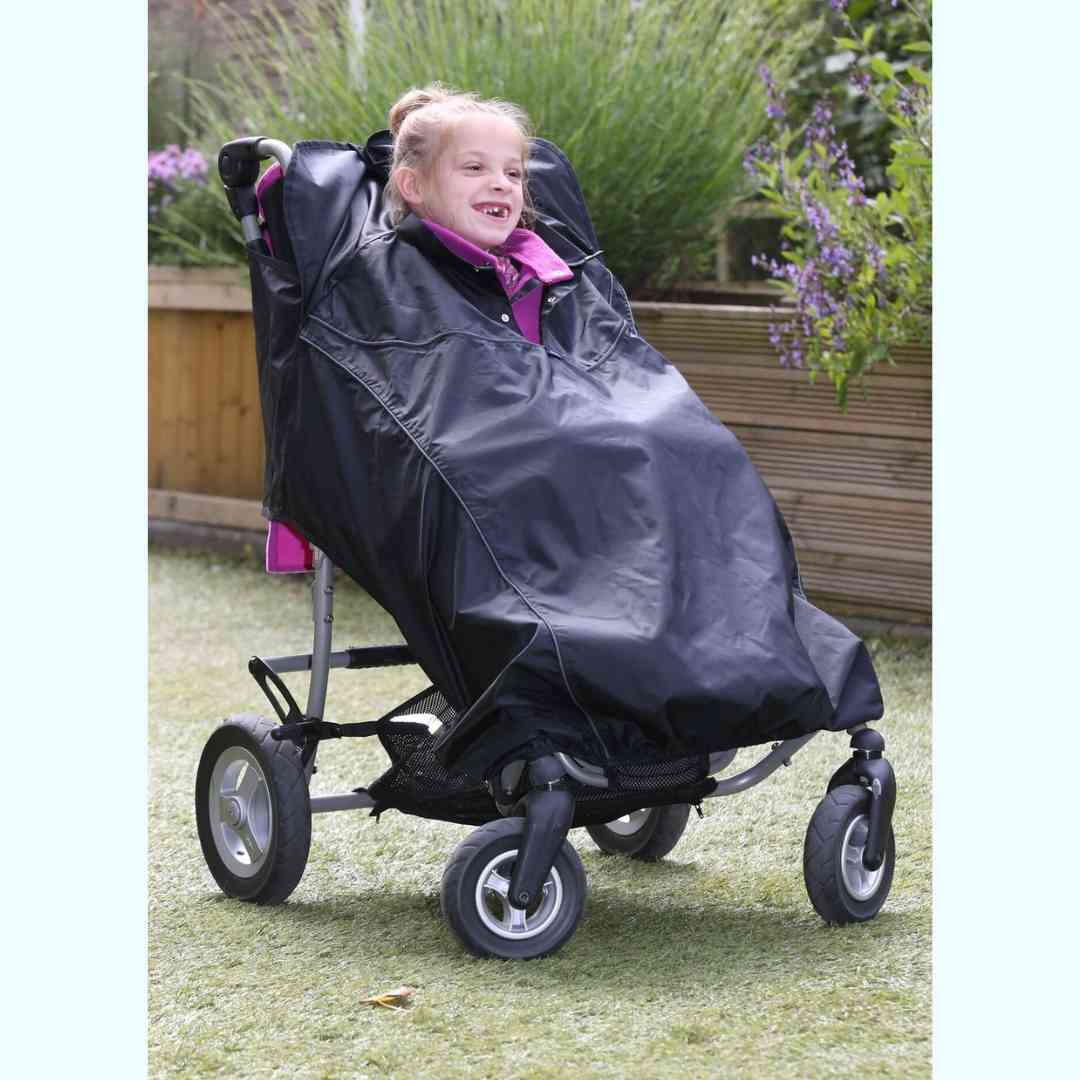 Little girl in a buggy has a waterproof cover protecting her from the rain