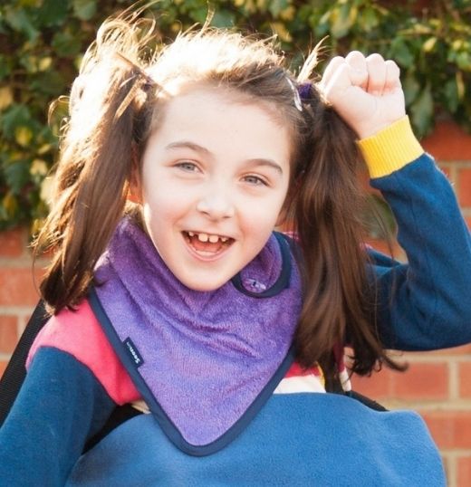 Little girl wears a purple bib.