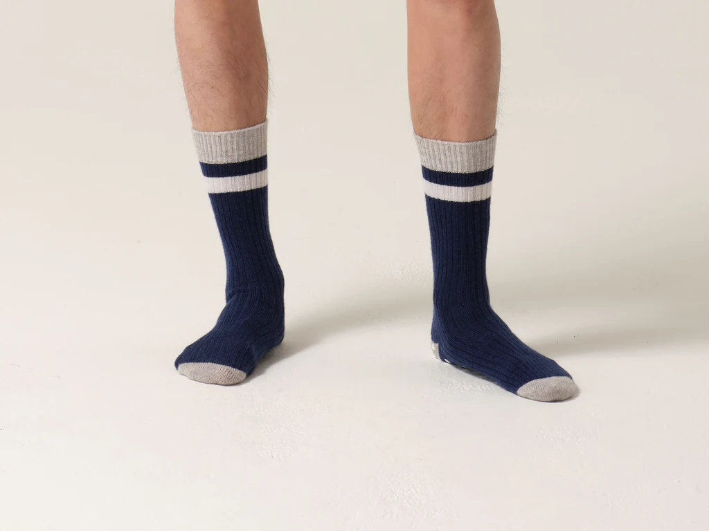 Man wears cashmere socks in navy and pale grey