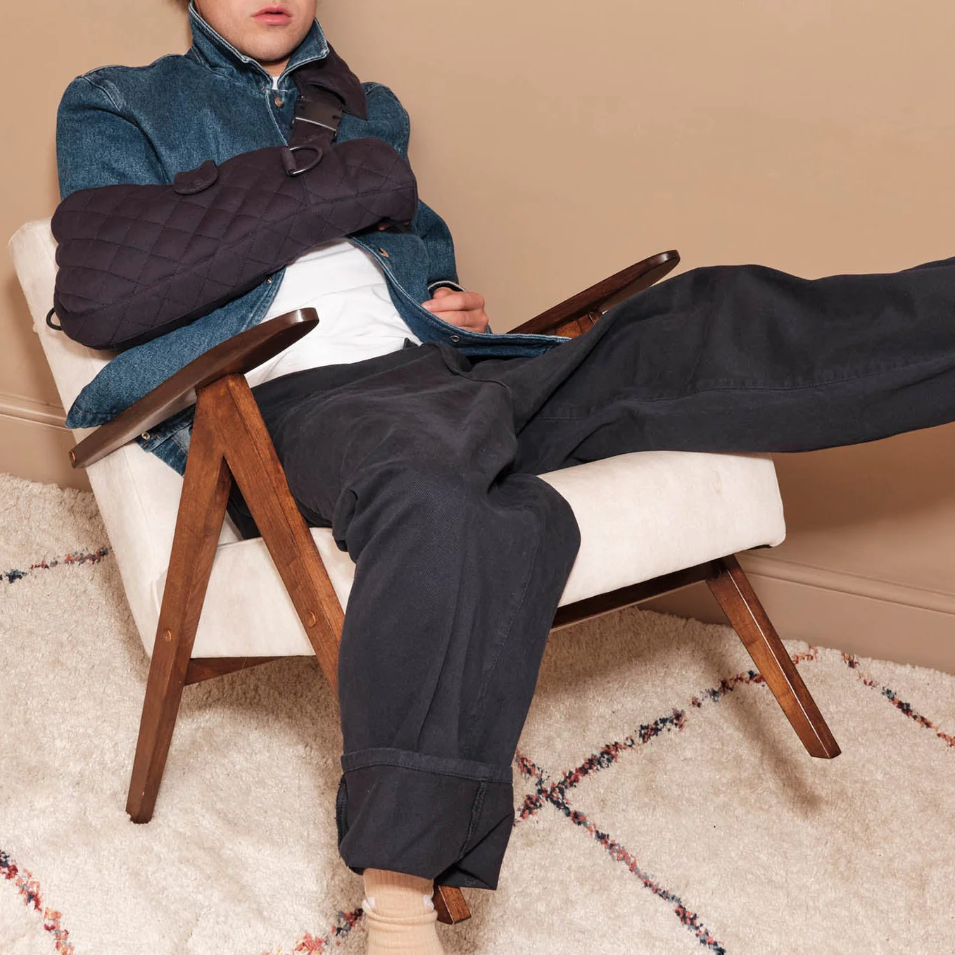 Man sits wearing navy blue sling