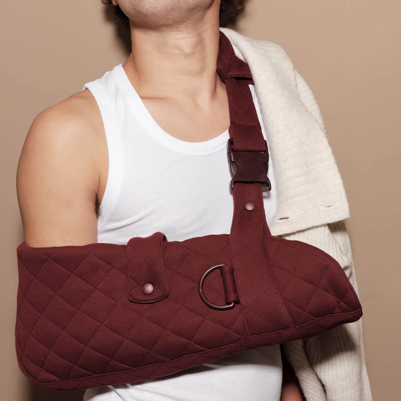 Man wears burgundy sling