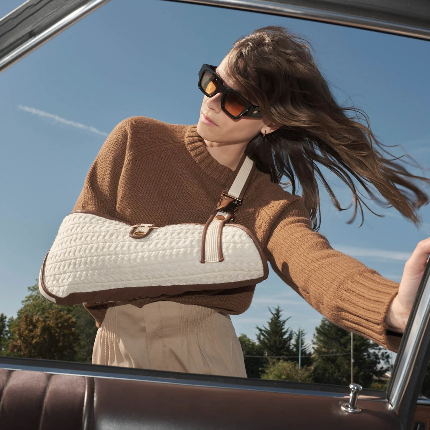 Woman wears cream quilted sling with tan brown trim
