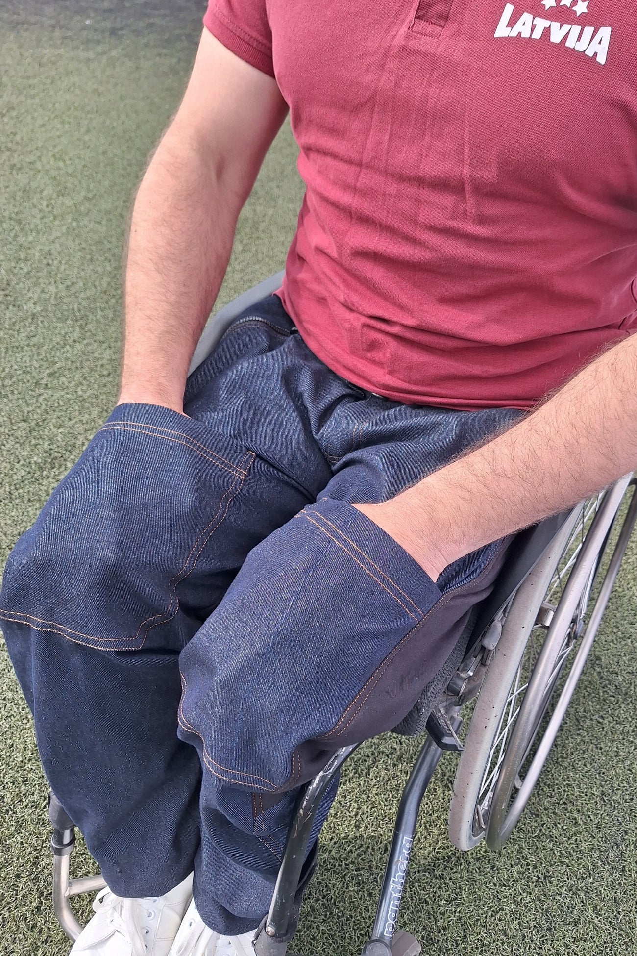 Man demonstrates pockets in the adaptive jeans with drop down front