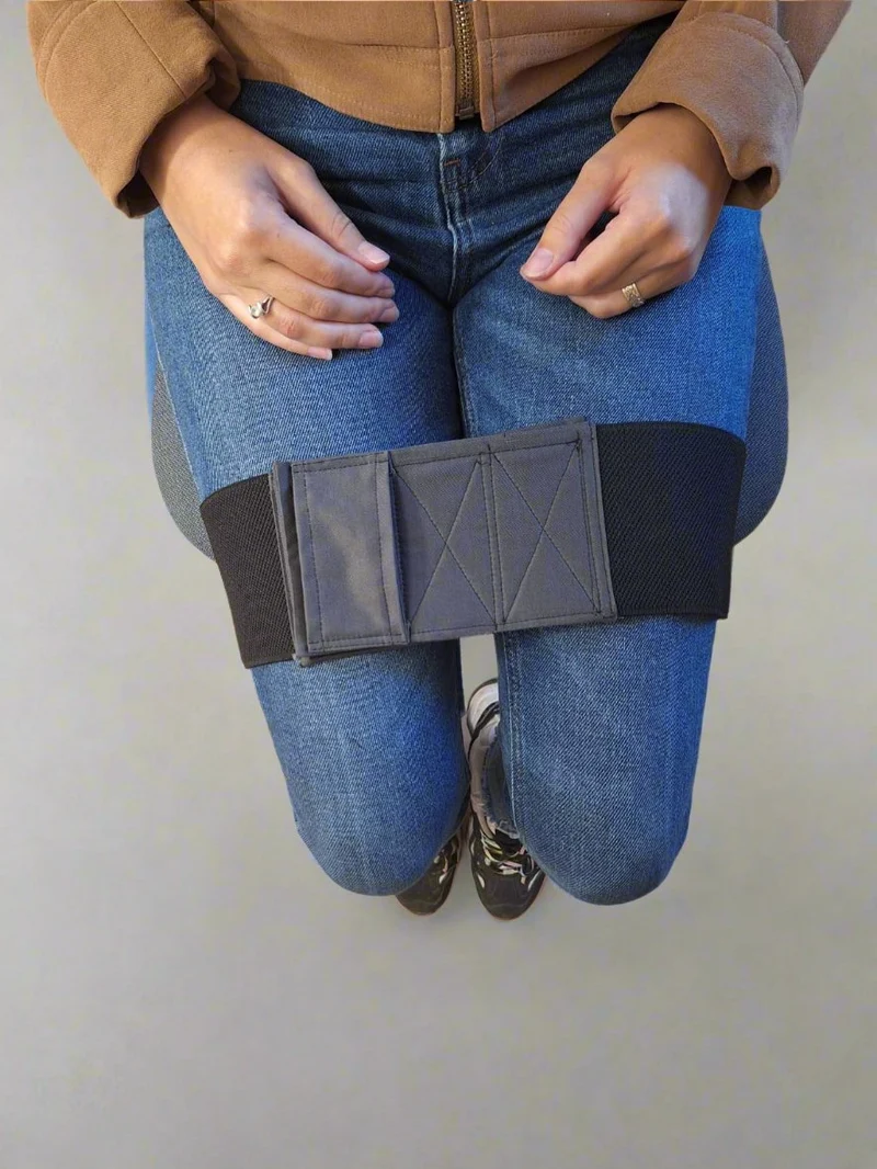 Black leg strap worn by a woman in jeans