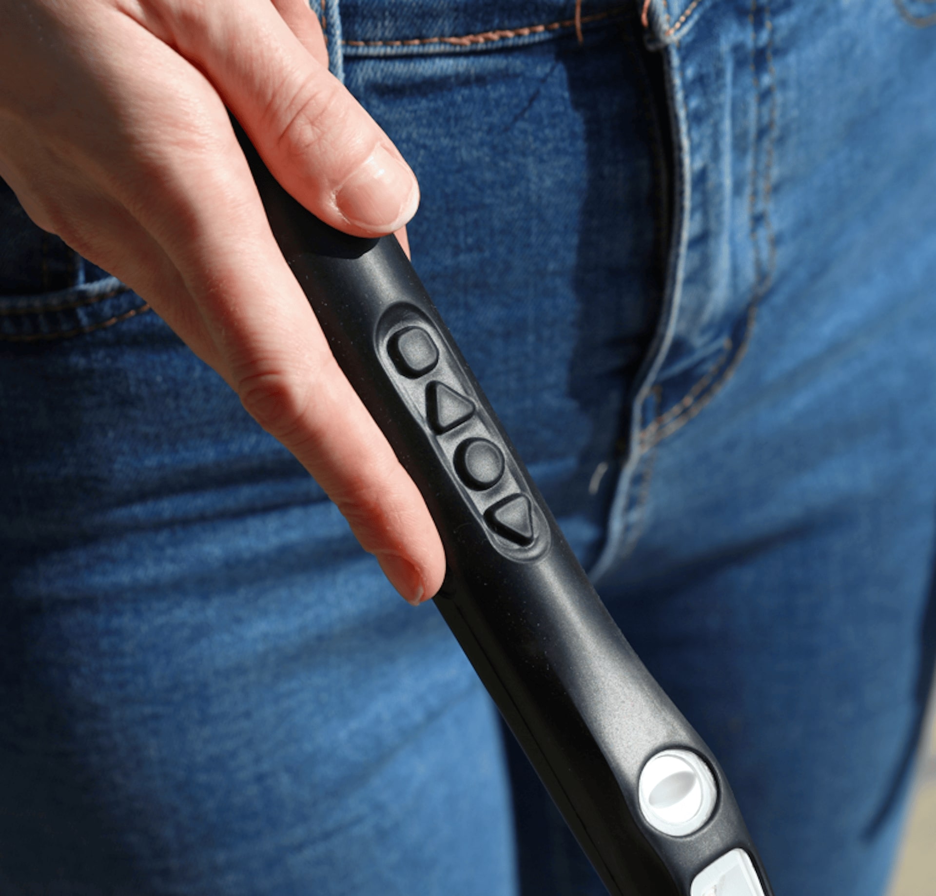 Woman wearing blue jeans demonstrates the buttons on the can handle