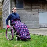 a woman in a wheelchair smiling with the purple and pink flamingo design cover