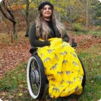 a woman in a wheelchair smiling with the yellow zebra design cover