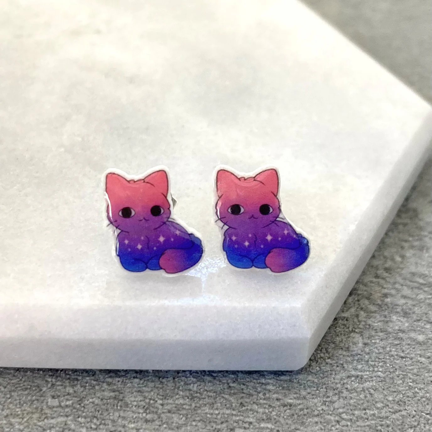 Purple and pink cat earrings to indicate bisexuality