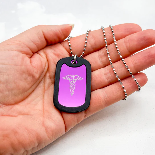Hand shows pink medical alert dog tag necklace