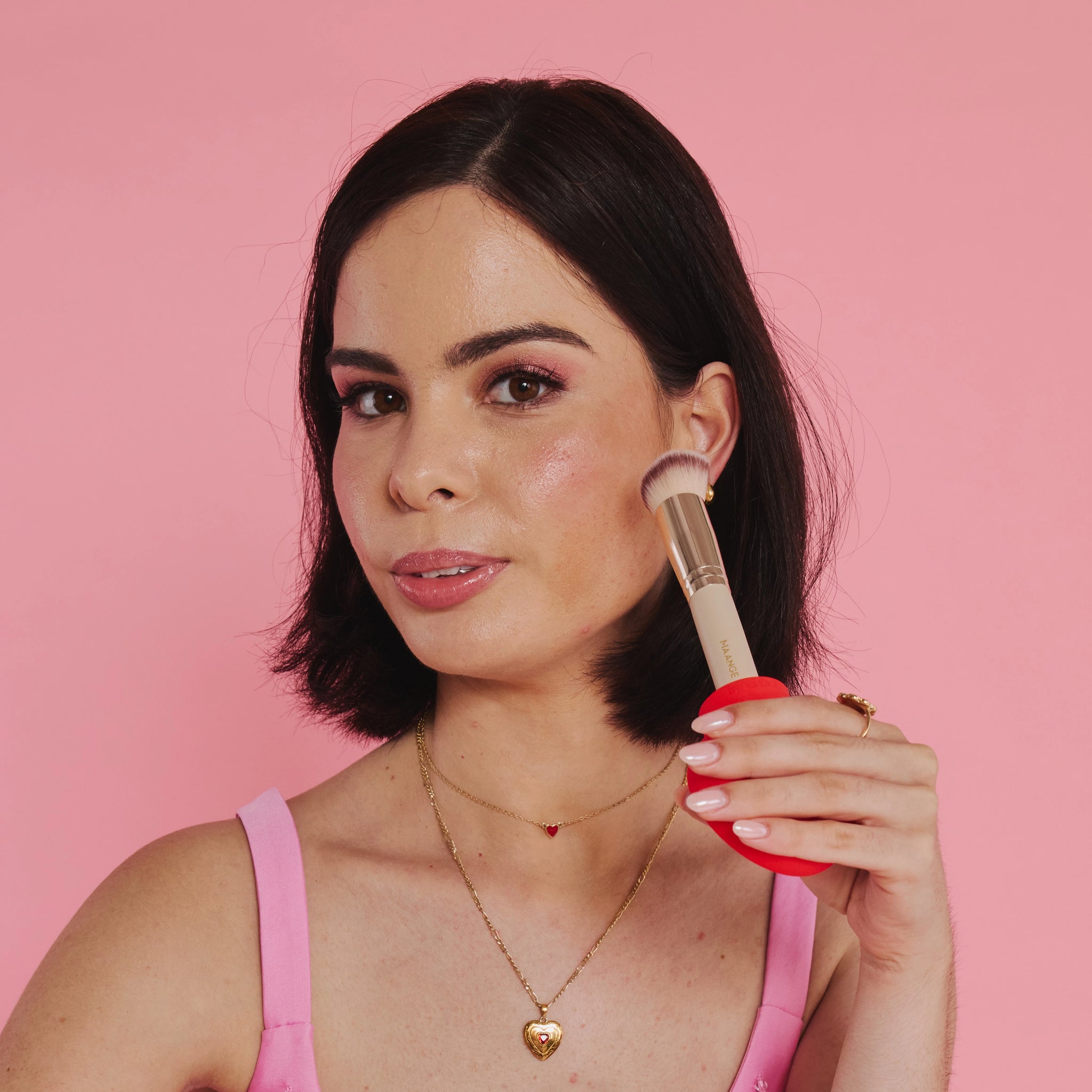 Model applies blusher using a brush fitted to a Margie, a flat paddle silicon tool