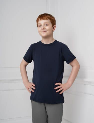 Boy with red hair wears black t shirt with hands on hips