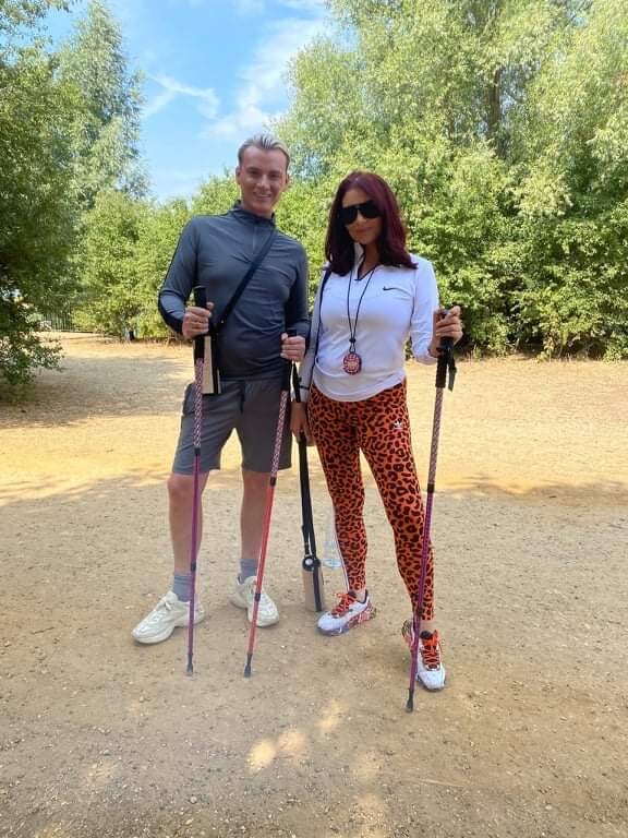 Man and woman are shown using sticks to hike with.