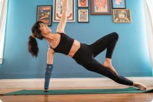 a woman in black gym clothing doing a yogo pose with a koala arm prosthetic