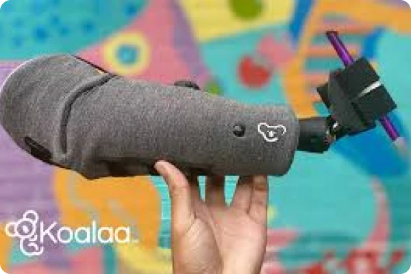 a grey fabric child arm prosthetic gripping a purple pencil with the koala prosthetics logo