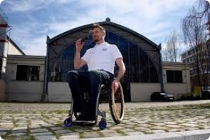 a man in a wheelchair wearing rollitex jeans in dark denim and a white t shirt