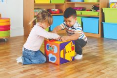 A girl and a boy play with a soft 'getting ready' cube which aids self dressing