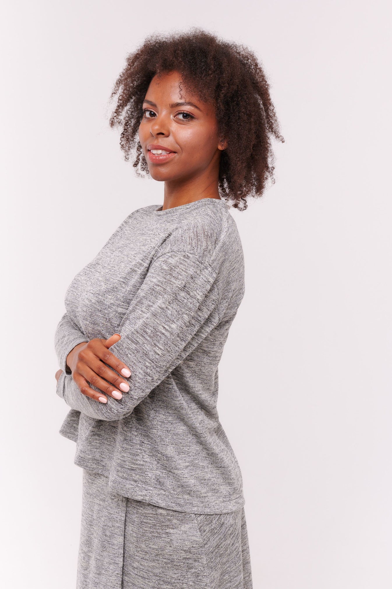 Woman wears grey top and skirt