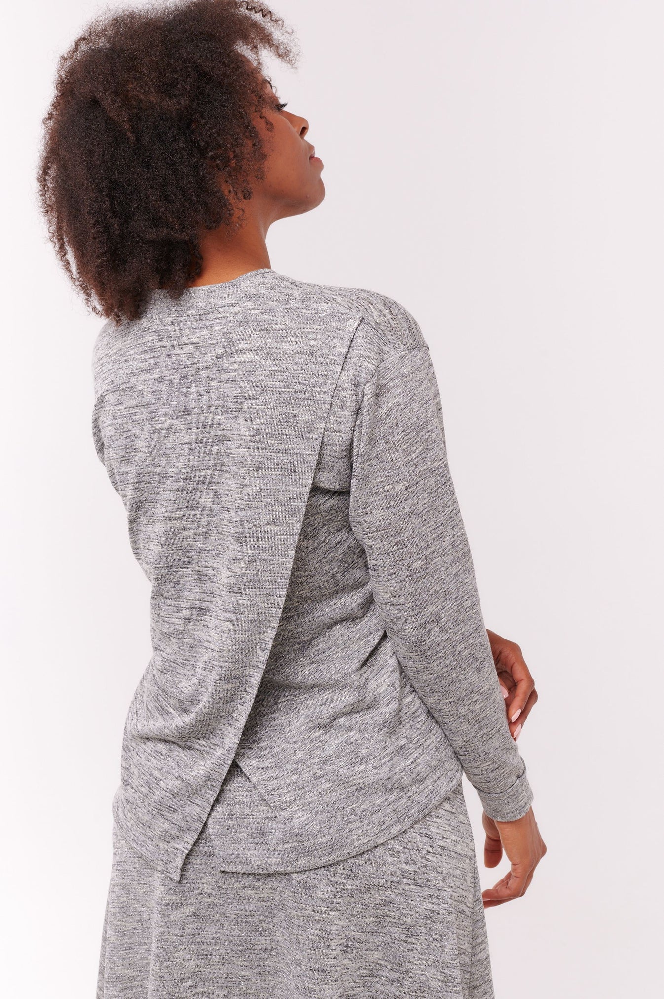Woman wears rear opening grey top