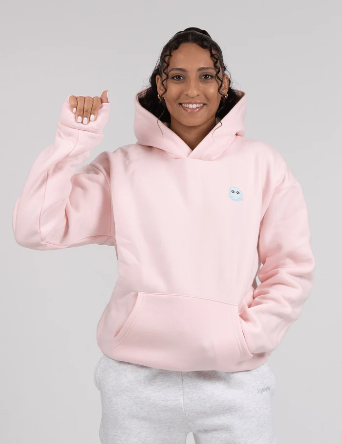 Woman demonstrates padded area on a baby pink hoodie
