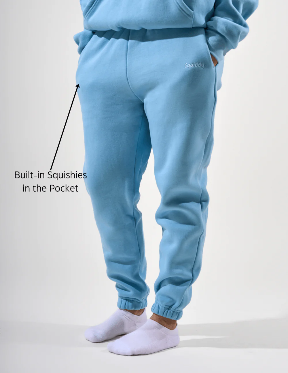 Man wears joggers in sky blue as arrow and text points to the built-in squishy in the pocket.