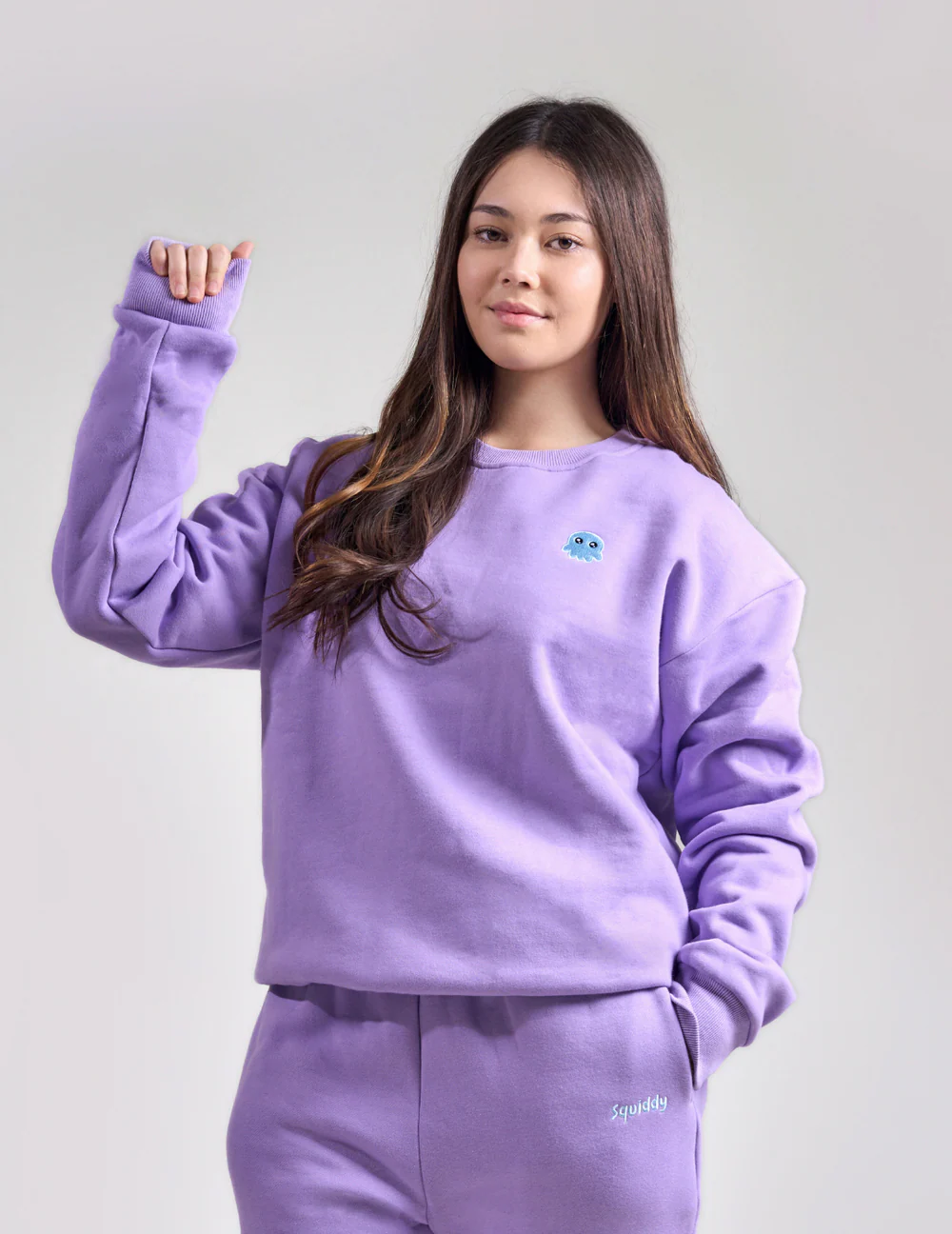 Woman wears sweatshirt and matching joggers in lavendar.
