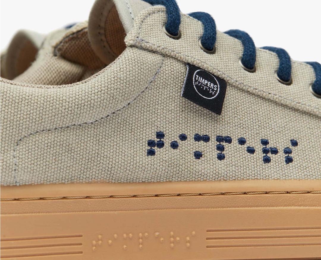 Close up view of Timperes written in Braille in navy blue to match the shoelaces.